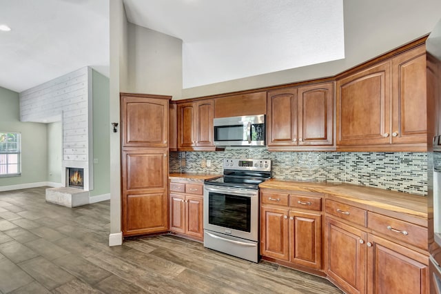 kitchen featuring dark stone countertops, a wealth of natural light, dark wood-type flooring, and vaulted ceiling