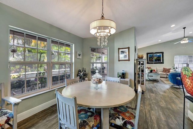 dining area featuring ceiling fan with notable chandelier, dark hardwood / wood-style flooring, and lofted ceiling