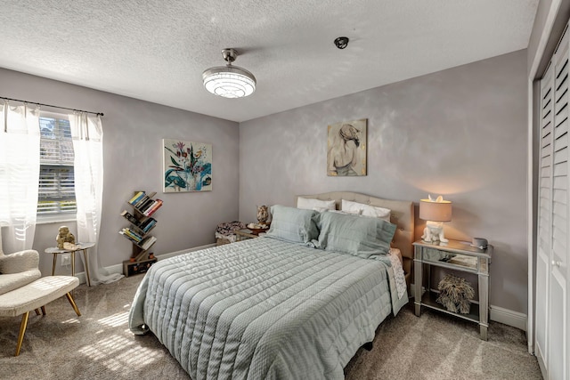 carpeted bedroom with a closet and a textured ceiling