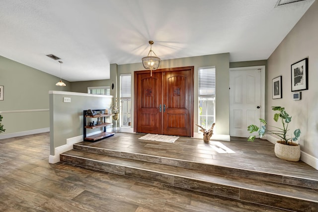 foyer with dark hardwood / wood-style flooring and vaulted ceiling