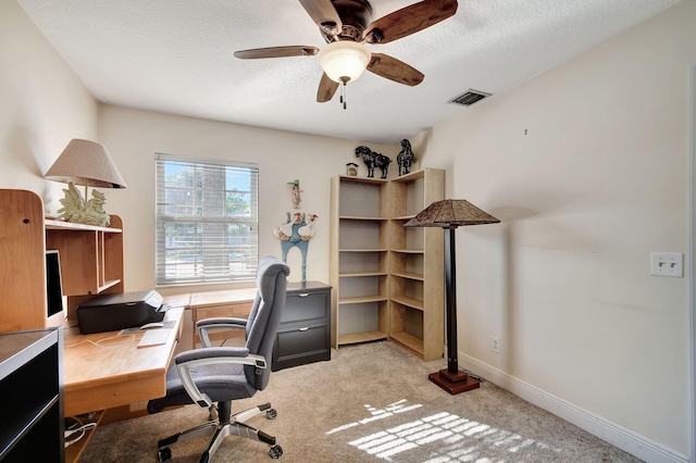 office space with a textured ceiling, ceiling fan, and light carpet