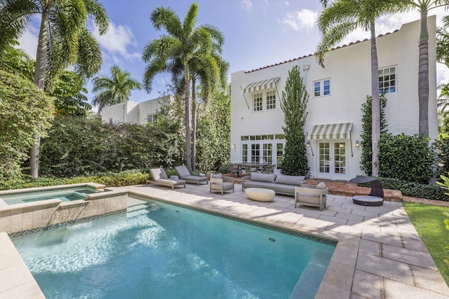 back of house with a swimming pool with hot tub, an outdoor hangout area, a patio, and french doors