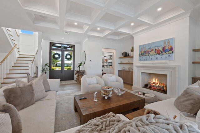 living room featuring coffered ceiling, hardwood / wood-style floors, beam ceiling, and crown molding