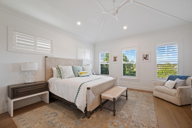 bedroom with hardwood / wood-style floors, crown molding, vaulted ceiling, and ceiling fan