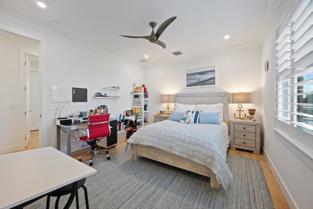 bedroom with crown molding, light hardwood / wood-style flooring, ceiling fan, and ensuite bath