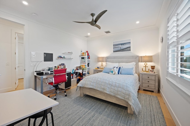 bedroom with ornamental molding, ceiling fan, and light hardwood / wood-style flooring