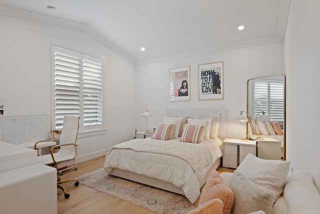 bedroom featuring crown molding, vaulted ceiling, and light wood-type flooring