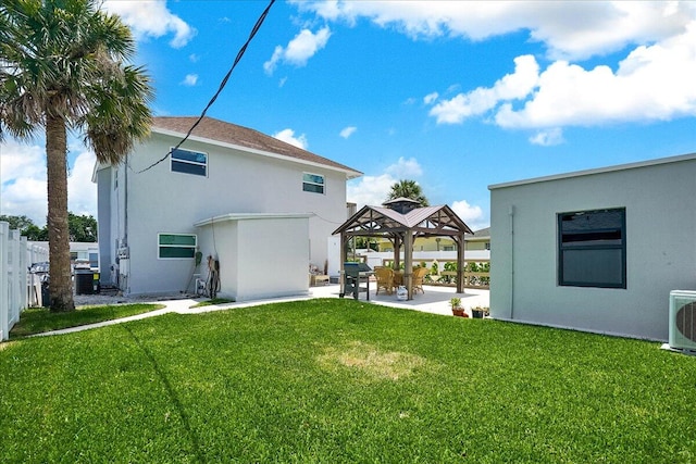 back of property with ac unit, a gazebo, a patio, and a lawn