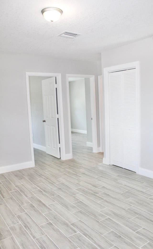 empty room featuring light hardwood / wood-style flooring and a textured ceiling