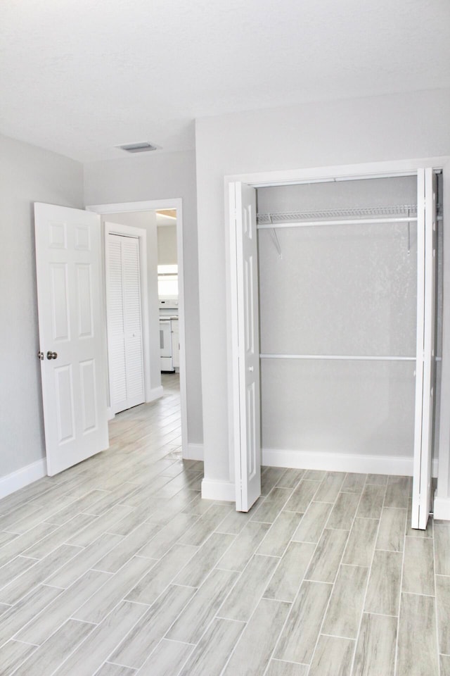 unfurnished bedroom with a closet and light hardwood / wood-style flooring