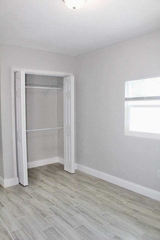 unfurnished bedroom featuring a closet and light hardwood / wood-style floors