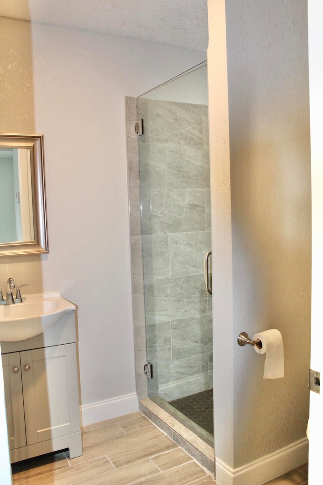 bathroom featuring hardwood / wood-style floors, vanity, and an enclosed shower