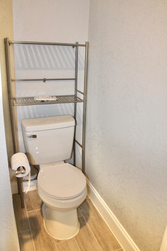 bathroom with hardwood / wood-style floors and toilet