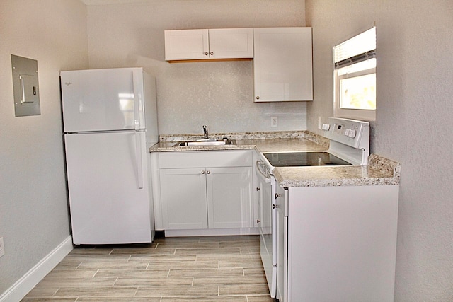 kitchen with electric panel, white cabinetry, sink, and white appliances