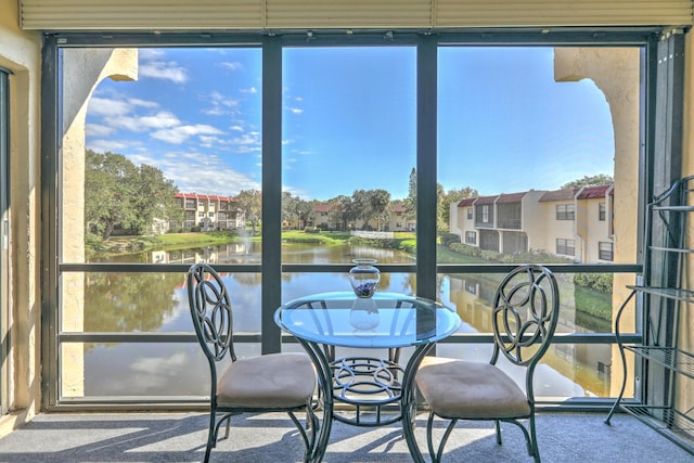 sunroom / solarium featuring a water view