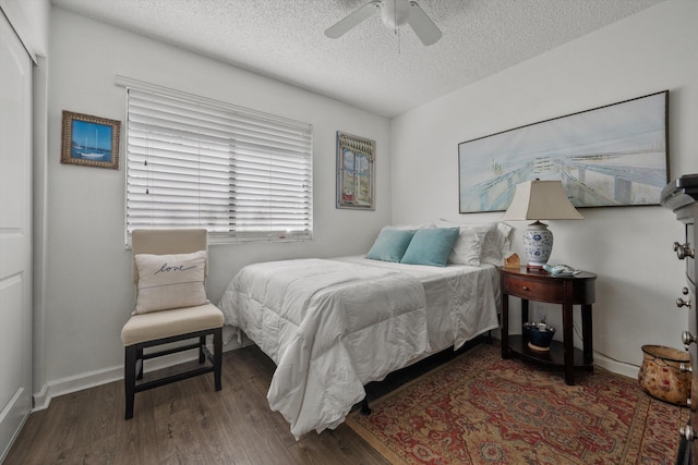 bedroom featuring ceiling fan, dark hardwood / wood-style flooring, and a textured ceiling