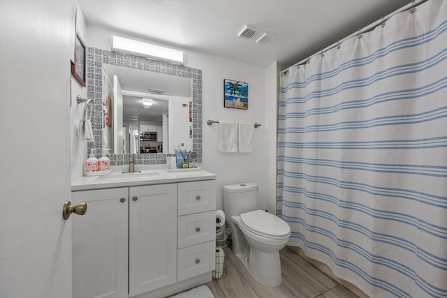 bathroom featuring vanity, toilet, and walk in shower