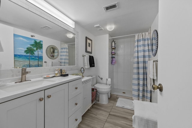 bathroom featuring curtained shower, tile patterned flooring, vanity, and toilet