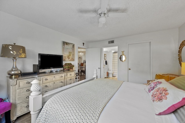 bedroom featuring ensuite bath, ceiling fan, hardwood / wood-style floors, and a textured ceiling