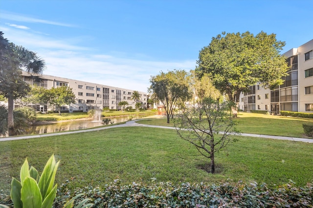 view of community with a lawn and a water view