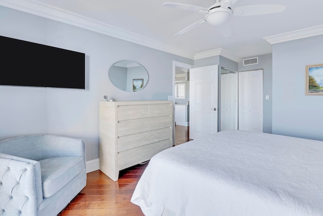 bedroom featuring ceiling fan, dark hardwood / wood-style floors, and crown molding