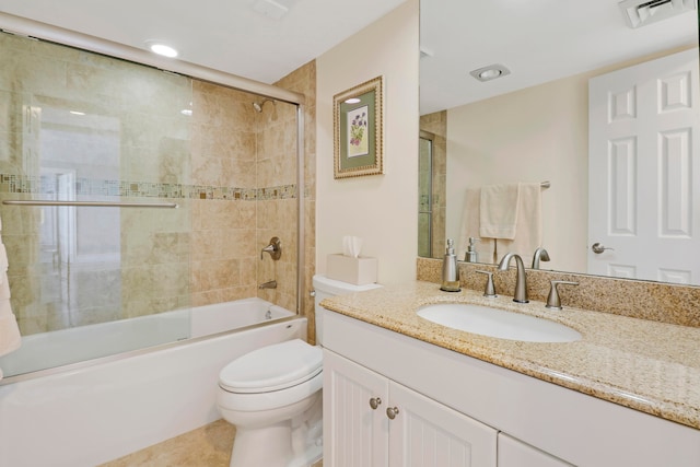 full bathroom with tile patterned floors, vanity, toilet, and bath / shower combo with glass door