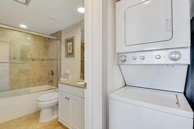 full bathroom featuring tile patterned flooring, enclosed tub / shower combo, stacked washer / drying machine, toilet, and vanity