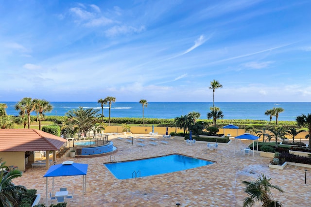 view of swimming pool featuring a water view and a patio area