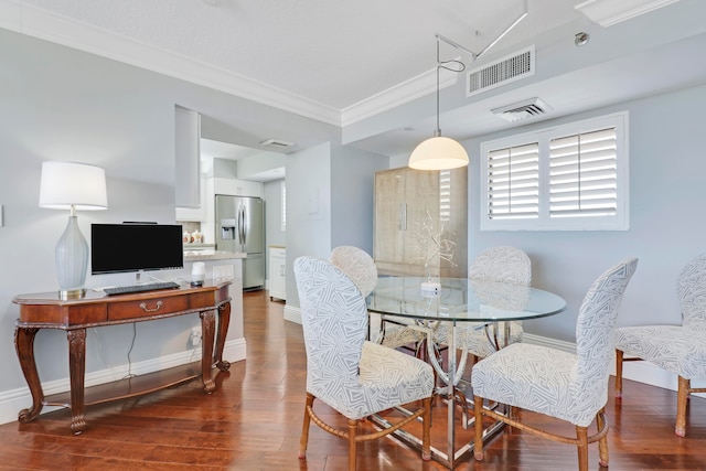 dining room with dark hardwood / wood-style floors and crown molding