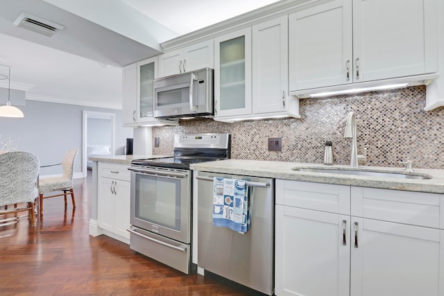 kitchen with sink, stainless steel appliances, dark hardwood / wood-style floors, decorative backsplash, and white cabinets