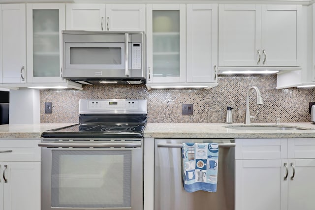 kitchen with white cabinets, backsplash, and stainless steel appliances