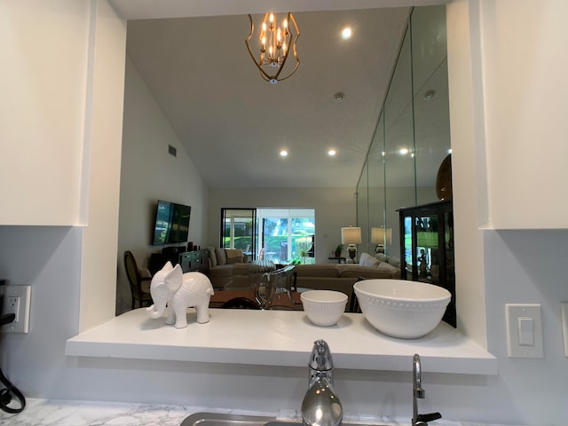 living room with a chandelier and vaulted ceiling