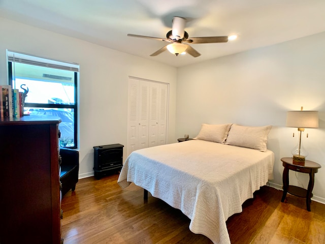 bedroom with ceiling fan, dark wood-type flooring, and a closet