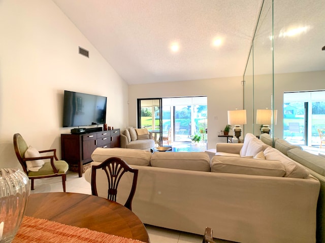 tiled living room featuring a textured ceiling and high vaulted ceiling