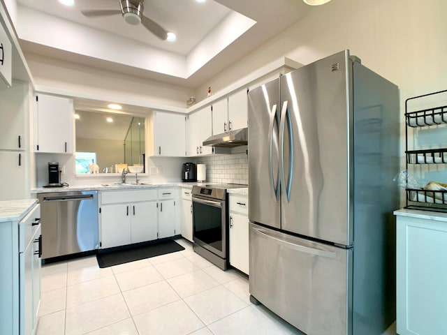 kitchen featuring appliances with stainless steel finishes, ceiling fan, sink, light tile patterned floors, and white cabinets