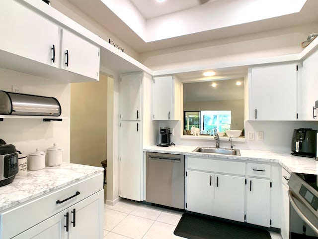 kitchen with light tile patterned flooring, sink, white cabinetry, and stainless steel appliances