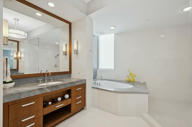 bathroom with vanity and independent shower and bath