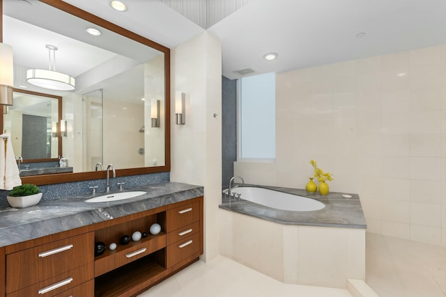 bathroom featuring tile patterned flooring, vanity, separate shower and tub, and tile walls