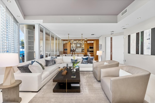 living room featuring an inviting chandelier and a raised ceiling