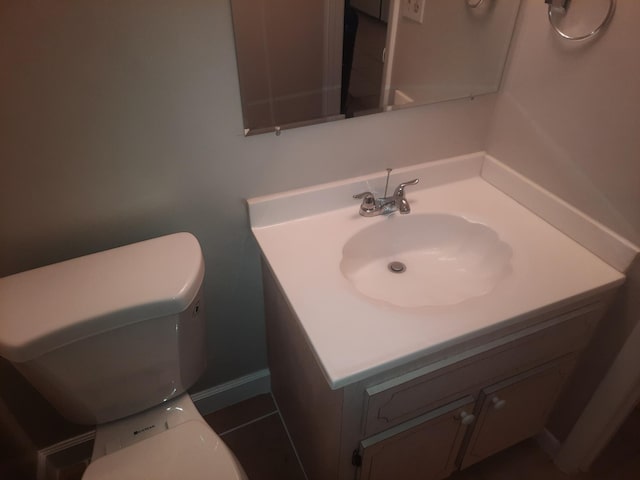 bathroom with tile patterned flooring, vanity, and toilet