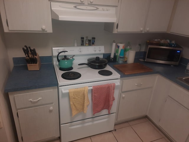 kitchen featuring white range with electric cooktop, white cabinets, and light tile patterned floors