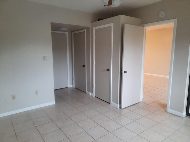 unfurnished bedroom featuring ceiling fan and light tile patterned flooring