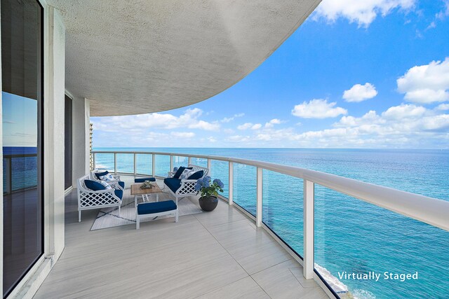 living room with a textured ceiling, a wall of windows, and a water view