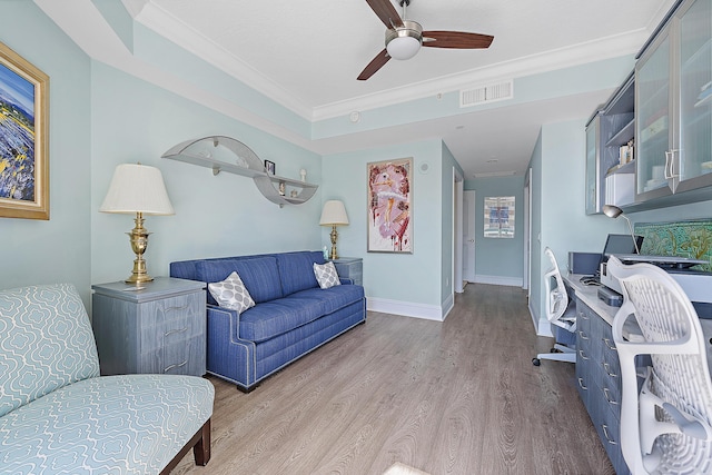 living room with crown molding, visible vents, a ceiling fan, wood finished floors, and baseboards