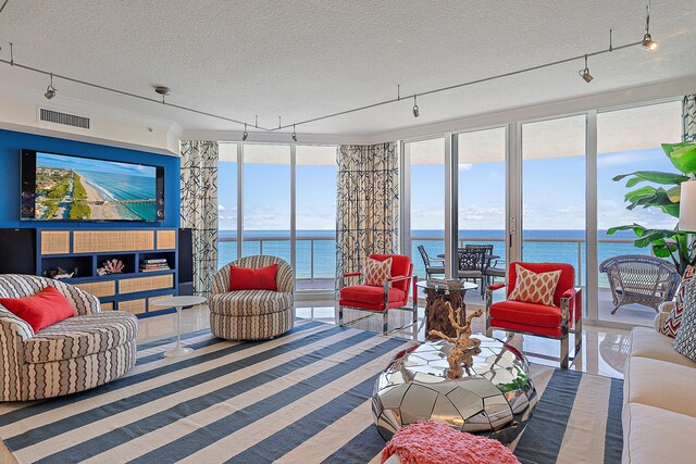 dining room featuring crown molding, floor to ceiling windows, a textured ceiling, and a water view