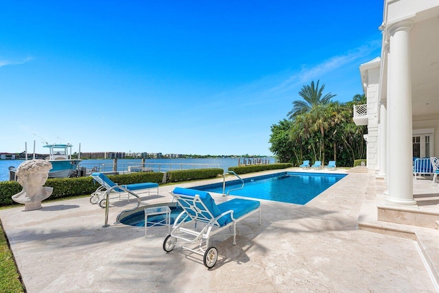 view of pool with a water view and a patio