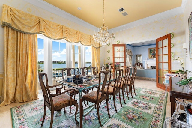 dining room with french doors, crown molding, wood-type flooring, a water view, and a notable chandelier