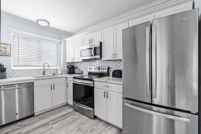 kitchen with light hardwood / wood-style flooring, stainless steel appliances, white cabinetry, and sink