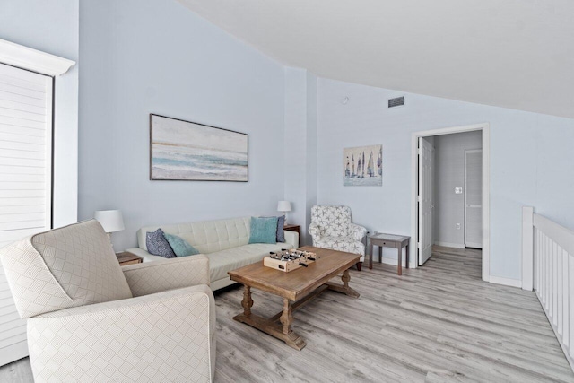 living room with light hardwood / wood-style floors and lofted ceiling