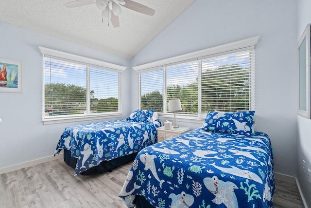 bedroom featuring multiple windows, a textured ceiling, light hardwood / wood-style flooring, and ceiling fan